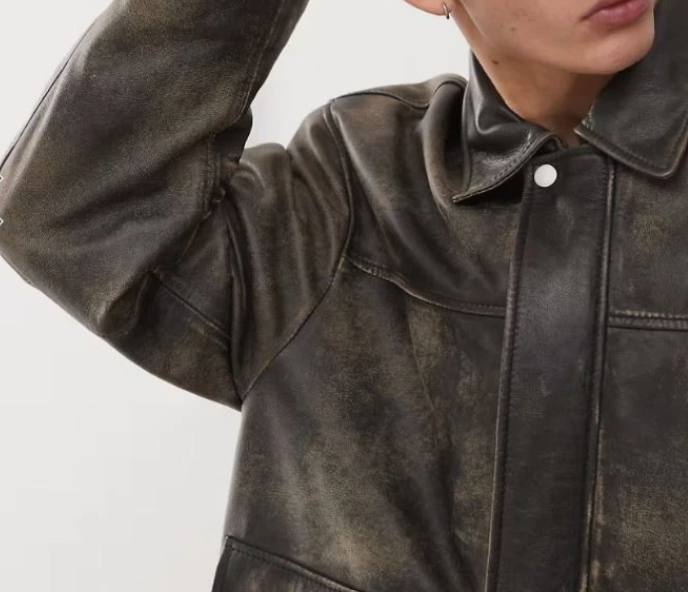 Close-up of washed distressed finish on a men's genuine leather trucker jacket